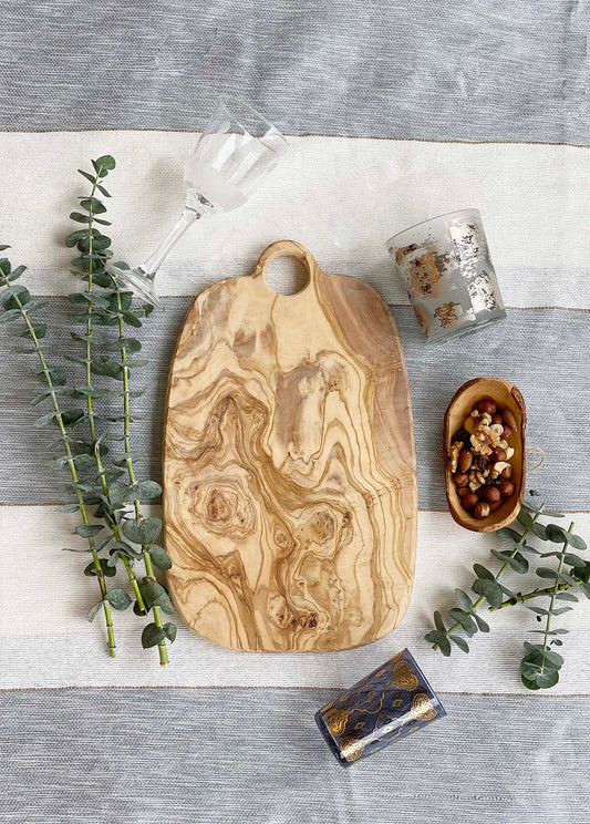 This modern olive wood board with a nice handle can be used as a cutting board, a charcuterie or cheese board or even as a tapas tray. Designed in Italy and handmade in Tunisia.