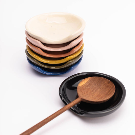  

A handmade stoneware spoon rest with a unique cut-out side perfectly cradles all shapes and sizes of kitchen tools with minimalist flair.
 