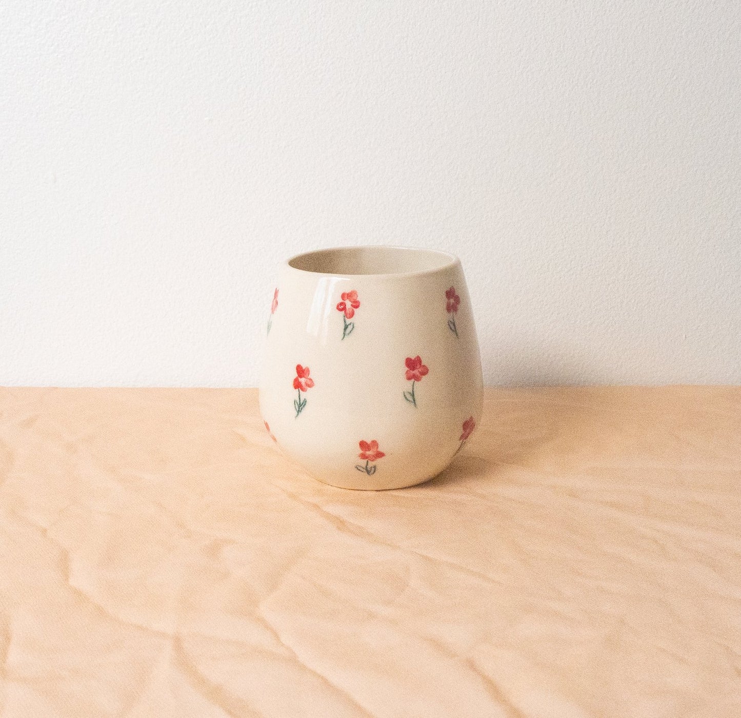 A handmade ceramic cup designed to emulate a stemless wine glass. This softly rounded cup is the perfect vessel for your beverage of choice-- coffee, tea, perrier, and of course wine. Made with food safe ceramic materials and painted by hand.