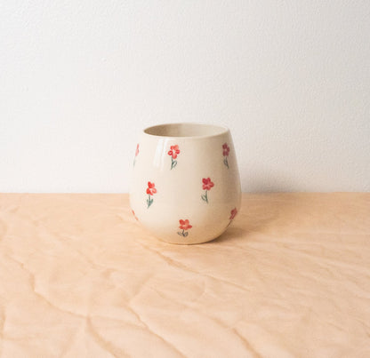 A handmade ceramic cup designed to emulate a stemless wine glass. This softly rounded cup is the perfect vessel for your beverage of choice-- coffee, tea, perrier, and of course wine. Made with food safe ceramic materials and painted by hand.