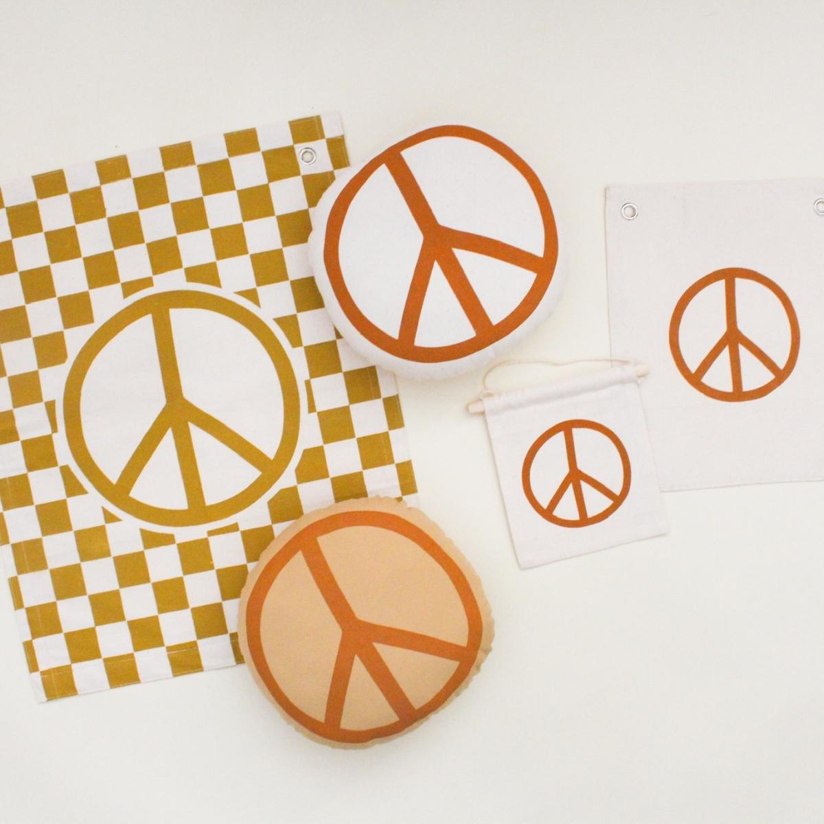 Rust peace sign on natural canvas hang sign with wooden dowel.&nbsp;Sewn and screen printed by hand on natural canvas by Kenyan artisans.