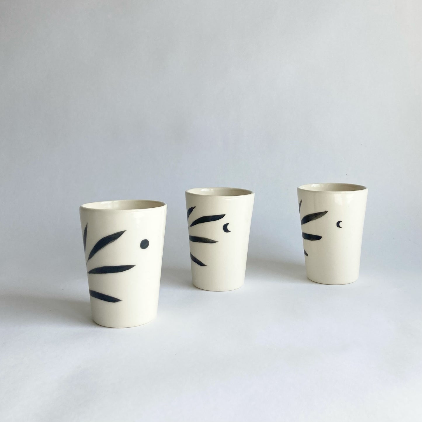 Slip casted ceramic cups in dover white (off white) and painted with black underglaze. Each cup is a little different. Some have full and some have a crescent moon. Handmade by Alicja in her Vermont studio.