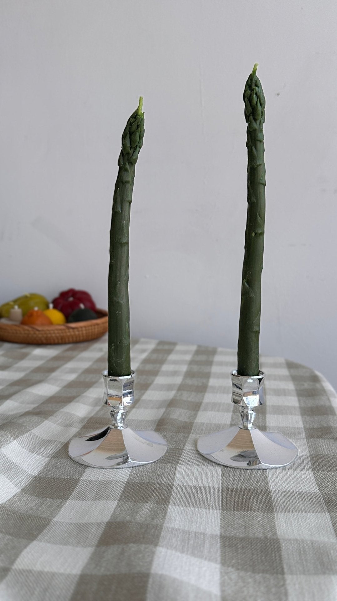 Beeswax tapers that have been meticulously shaped to resemble fresh asparagus stalks, these candles are a delightful fusion of artistry and nature. Made from pure beeswax, they emanate a natural, sweet aroma. Set of two.