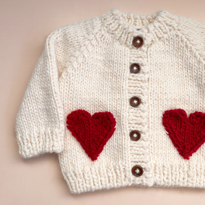 Your baby needs this chunky Cream cardigan with Red faux heart pockets. Perfect for a Valentine's Day outfit or just every day sweetness. Crafted with care using 100% Hand-knit Acrylic