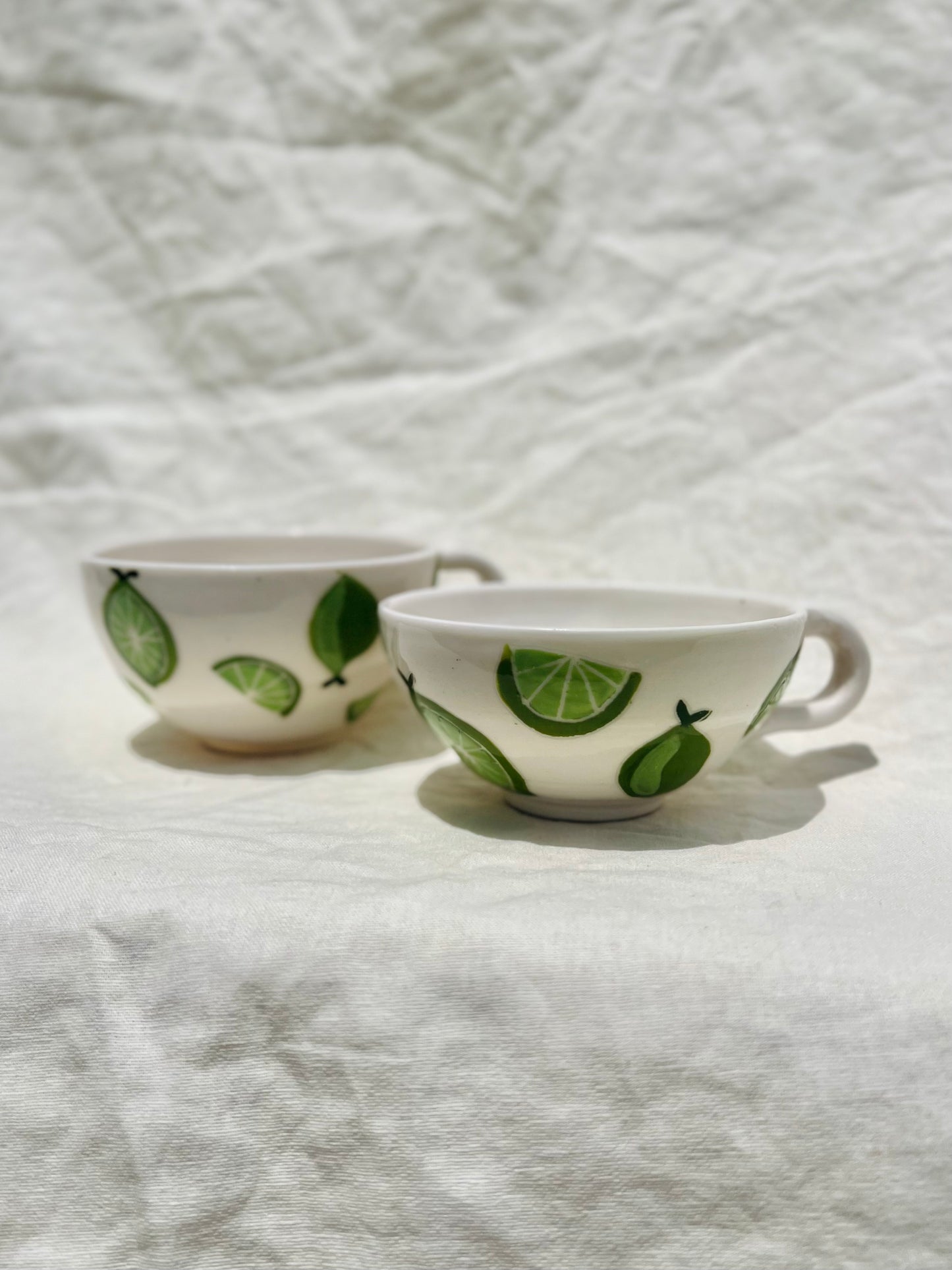 Handmade porcelain mug with hand painted limes. Made right here in Encinitas, California by Chandler Puritty. With its satisfying and ergonomic design, I think it's impossible not to feel good holding this mug and sipping your favorite tea or coffee.&nbsp;