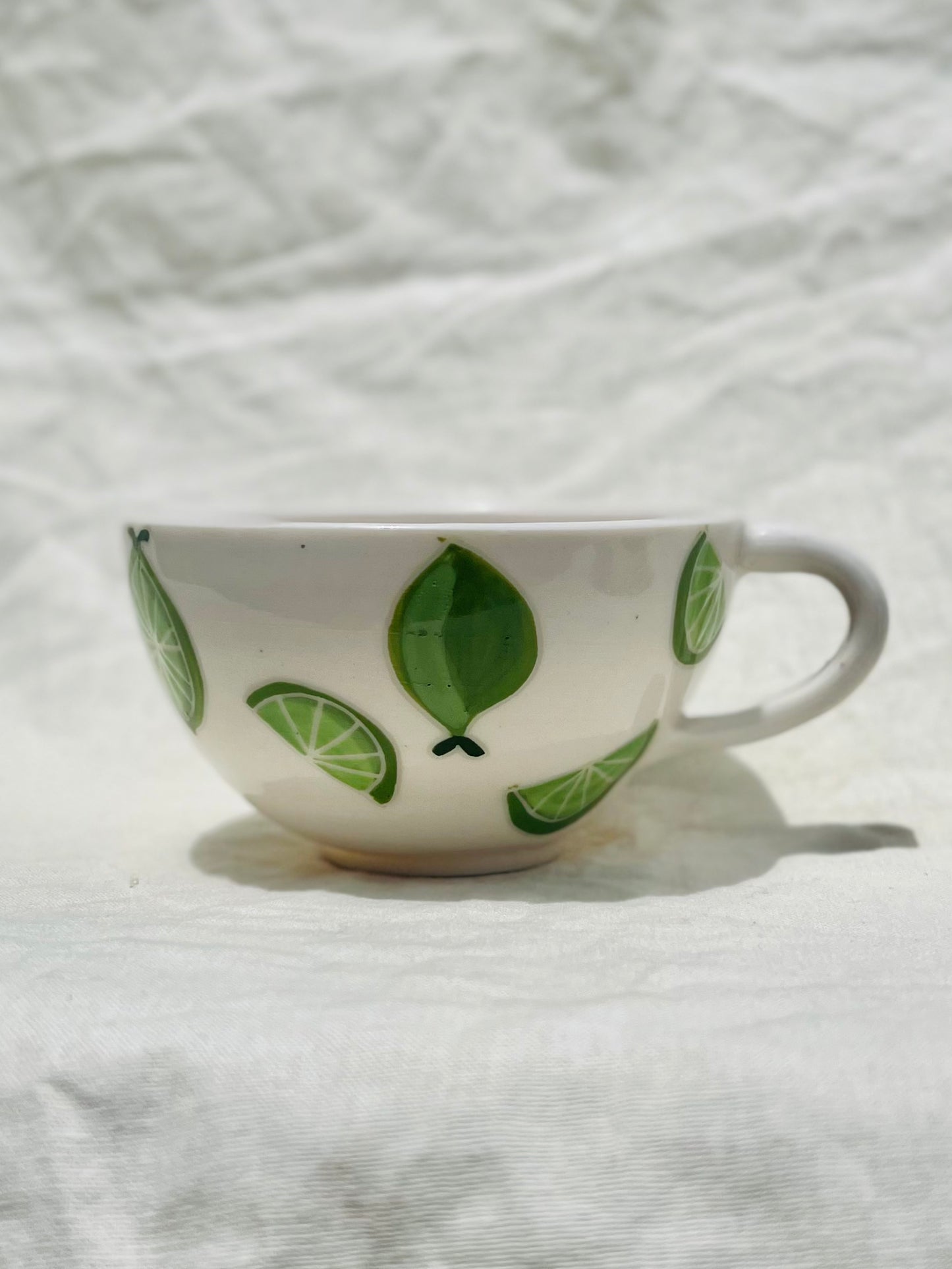 Handmade porcelain mug with hand painted limes. Made right here in Encinitas, California by Chandler Puritty. With its satisfying and ergonomic design, I think it's impossible not to feel good holding this mug and sipping your favorite tea or coffee.