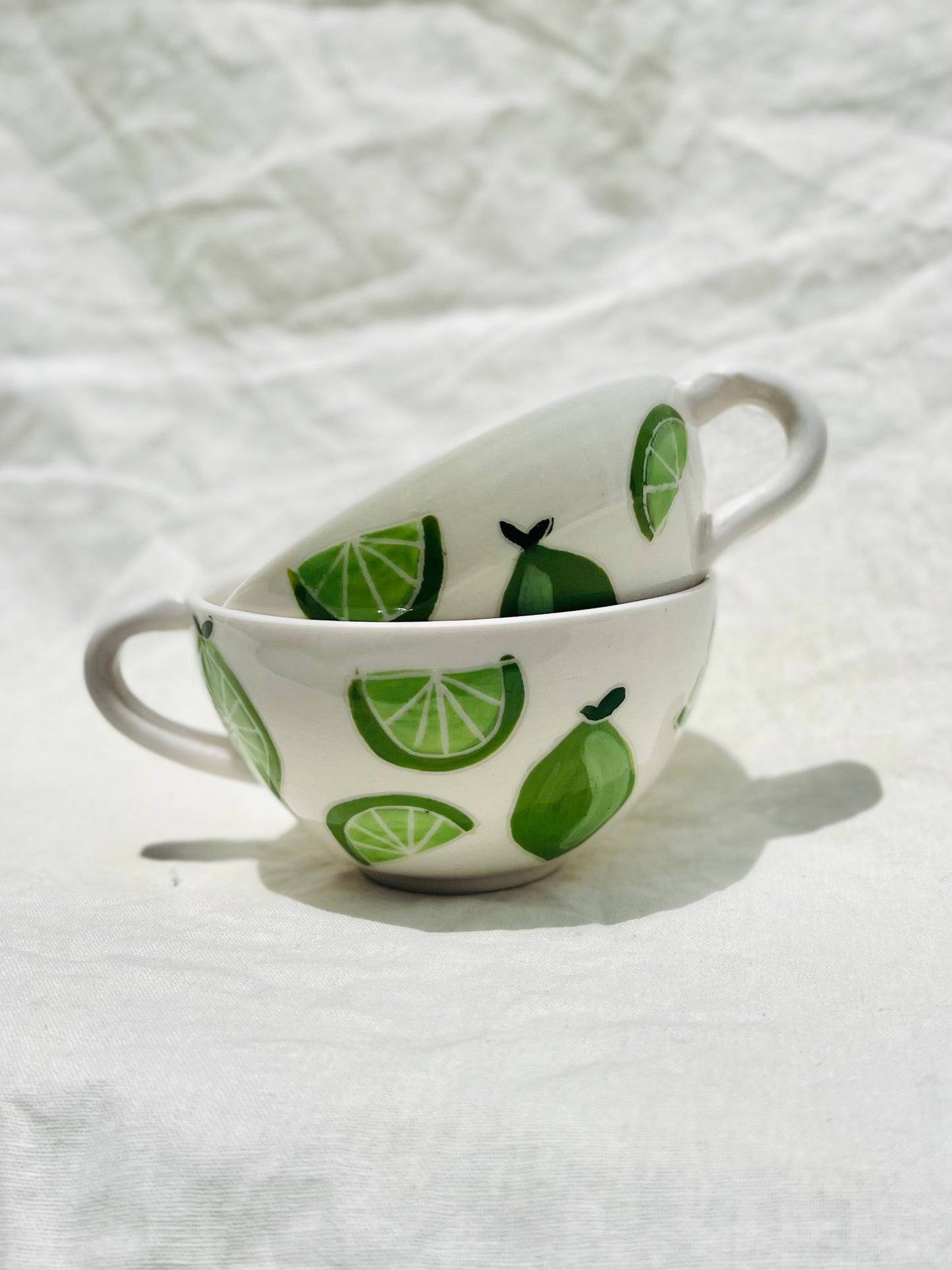 Handmade porcelain mug with hand painted limes. Made right here in Encinitas, California by Chandler Puritty. With its satisfying and ergonomic design, I think it's impossible not to feel good holding this mug and sipping your favorite tea or coffee.