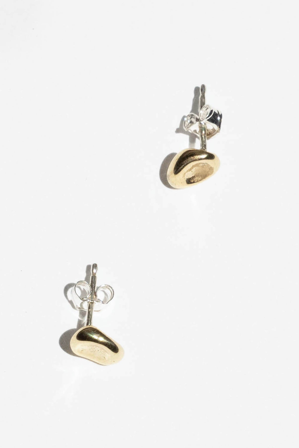 The Puddle stud is inspired by a calm small body of water. Perfect alone or in a second ear piercing.   Hand carved and cast with a high polished mirror finish. Available in solid brass or sterling silver.