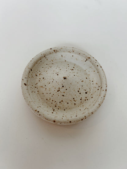 A speckled matte white ceramic incense holder. Handmade in Berkeley, CA by Lisa Fontaine.