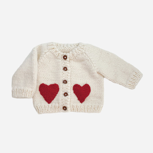 Your baby needs this chunky Cream cardigan with Red faux heart pockets. Perfect for a Valentine's Day outfit or just every day sweetness. Crafted with care using 100% Hand-knit Acrylic