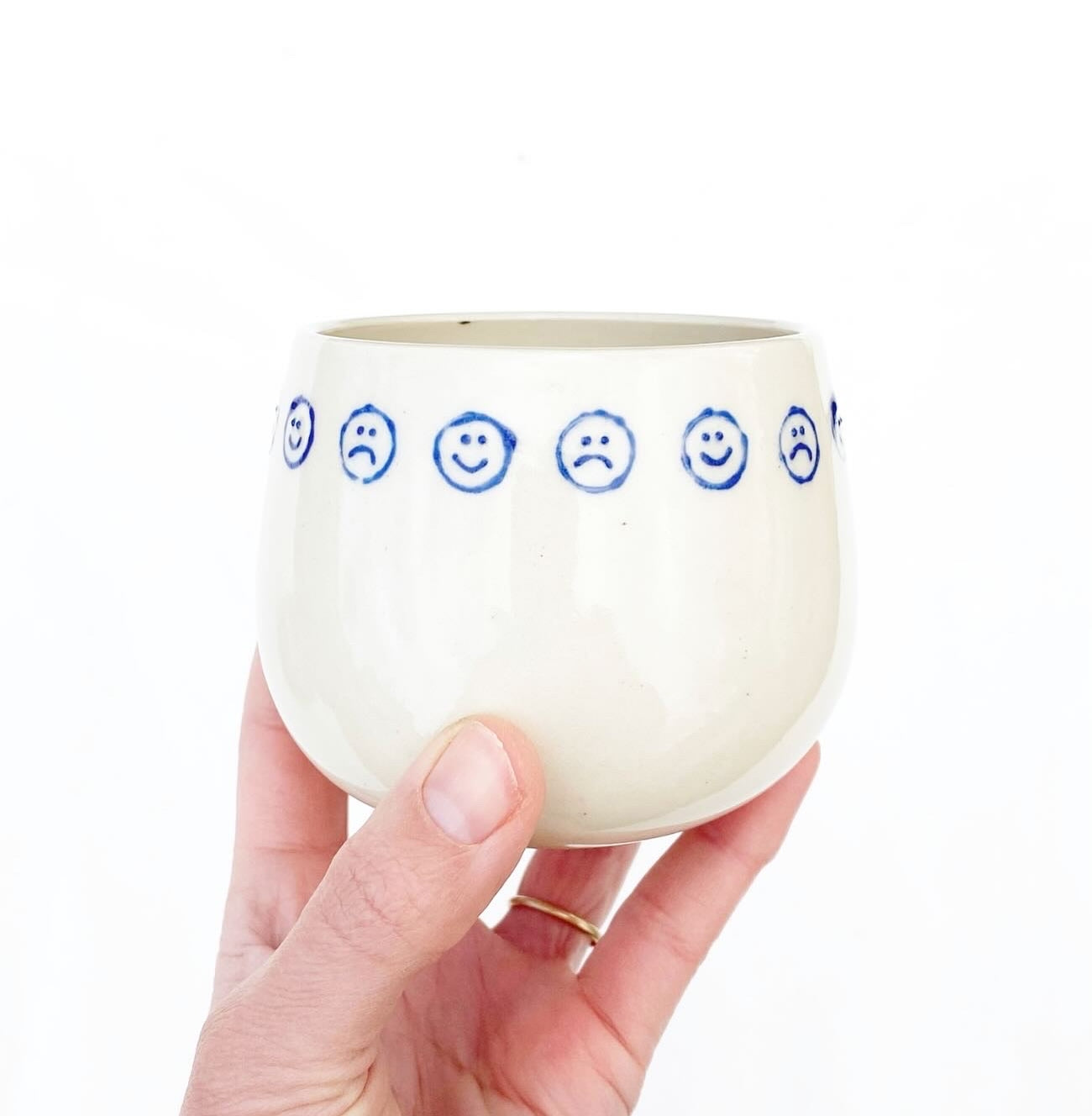 Hand-thrown cream stoneware with alternating happy sad faces in cobalt. Made in Virginia, USA by Korai Ceramics.