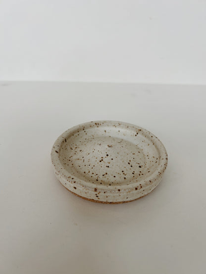 A speckled matte white ceramic incense holder. Handmade in Berkeley, CA by Lisa Fontaine.