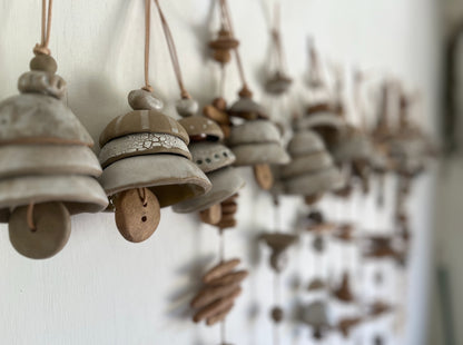 Ceramic bells. Each little bead and bell, unique. A mix of clay bodies and glazes with leather cord for hanging.   May they be a reminder of all the support around you. Each piece unique and made with love. Hand built, glazed and fired in Slo, Ca. 