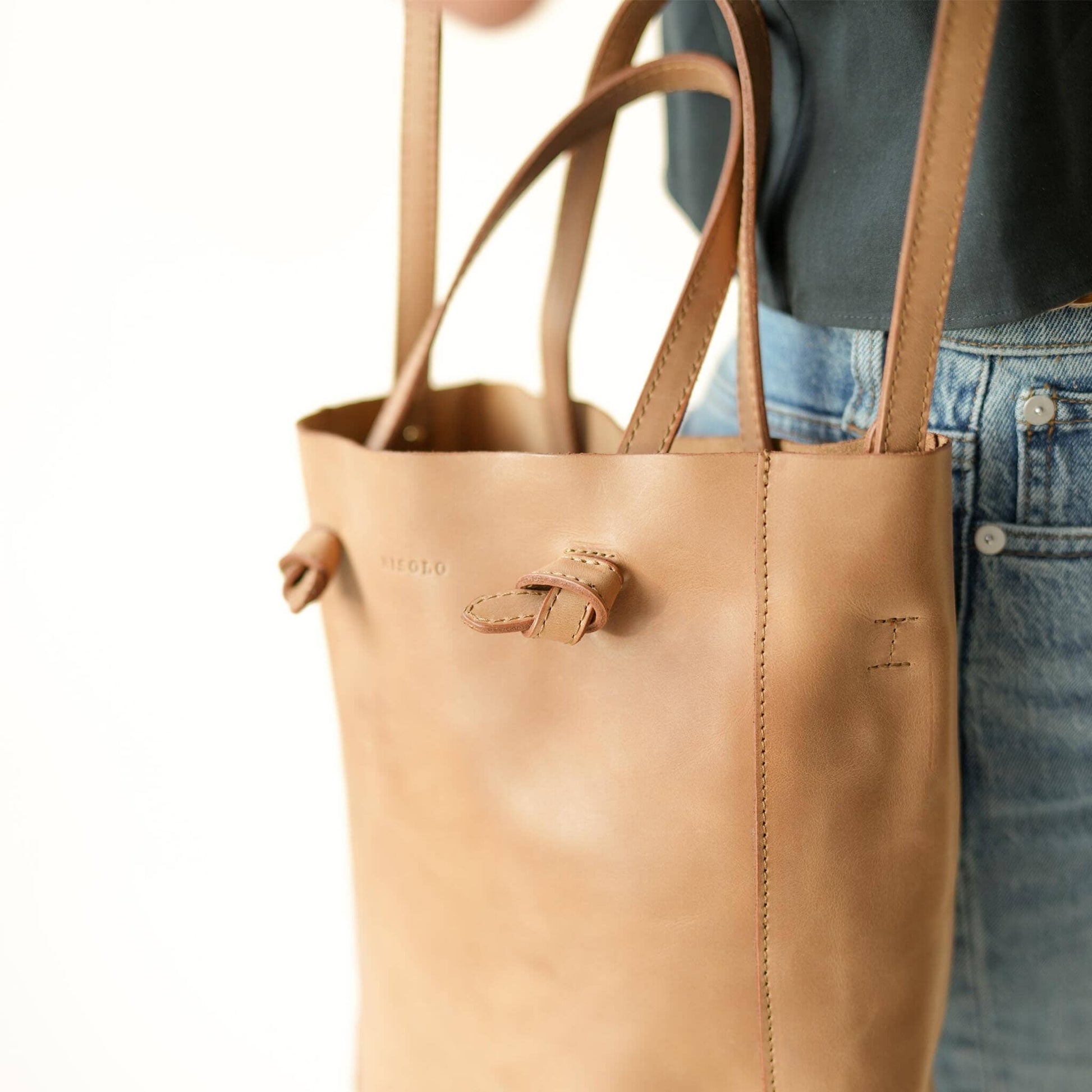 Nisolo Simone Convertible Shopper Bag - Dubbed “The Perfect Bag” because of its structure, shape, and size. Made to hold all the essentials for your day out of the house. Features removable and adjustable cross body strap to convert your handbag into an over the shoulder bag.