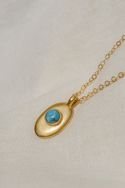 Sweet little handmade charm necklace featuring an ethically-mined turquoise stone. Available in bronze with gold plating and a gold filled chain or sterling silver chain.