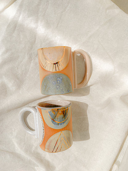 Handmade ceramic mug featuring unique glaze colors and a looped handle.