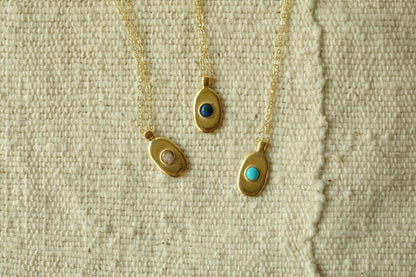 Sweet little handmade charm necklace featuring an ethically-mined turquoise or copper calcite stone stone. Bronze with gold plating and a gold filled chain.